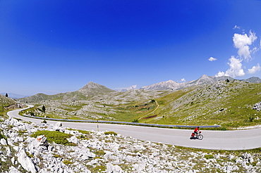 Cyclist on lonesome country road, Castel del Monte, Campo Imperatore, Abruzzi, Italy, Europe