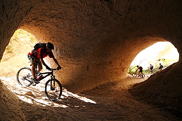 Mountainbiker in the tonnel of a river, Uchisar, Goereme, Cappadocia, Turkey