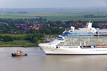 Tug boat navigating the newly launched Celebrity Equinox from the Meyer Werft along the River Ems, Lower Saxony, Germany