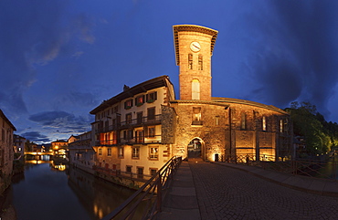 Illuminated church at a canal in the evening, Saint-Jean-Pied-de Port, Pyrenees Atlantiques, Suedfrankreich, Frankreich, Europe