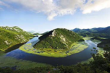 View of river Rijeka Crnojevica under clouded sky, River to Skadar Lake, Montenegro, Europe