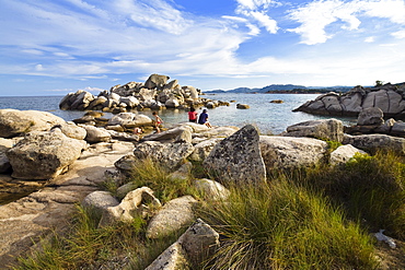 family in the rocks on the beach of Palombaggia, south-east coast, Corsica, France, Europe