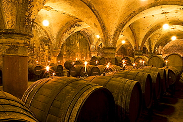 Candlelit barrels inside wine cellar of Eberbach abbey, a medieval monastery at Eltville am Rhein, Rheingau, Hesse, Germany, Europe