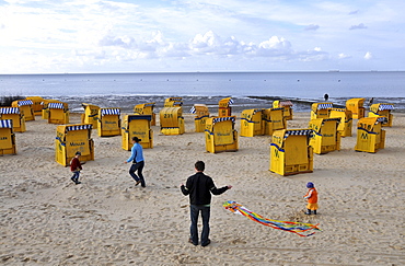 Family playing with a kite on the beach at Cuxhven, North Sea coast of Lower Saxony, Germany