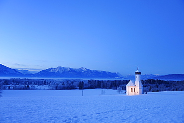 Snow covered church in front of range of Alps in the evening, Penzberg, Werdenfelser Land, Upper Bavaria, Bavaria, Germany, Europe