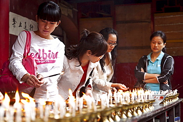 Oil lamps and butter lamps, women lighting candles, buddhist ritual, Luohan Temple, buddhist temple downtown, Chongqing, People's Republic of China