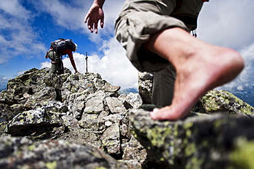 Two barefoot women on summit of Grosslitzner, Silvretta mountain range, Vorarlberg, Austria