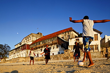 Children playing soccer on the beach of Stonetown, Zanzibar City, Zanzibar, Tanzania, Africa