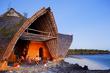 People in front of the Chumbe Island Coral Park Lodge at dusk, Restaurant in the Visitor Center, Chumbe Island, Zanzibar, Tanzania, Africa