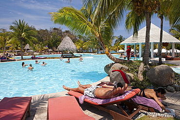 Couple relaxing by the swimming pool at Paradisus Rio de Oro resort, Playa Esmeralda, Guardalavaca, Holguin, Cuba