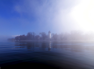 Misty scenery with tower of Frauenwoerth monastery in the background, Frauenchiemsee, Fraueninsel, Chiemgau, Bavaria, Germany