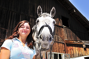 Portrait of a woman with a horse in front of the stable, Inn Valley, Upper Bavaria, Bavaria, Germany