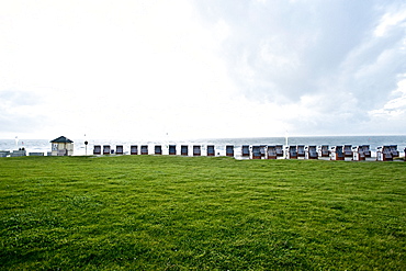 Roofed wicker beach chairs at promenade, Norderney, East Frisian Islands, Lower Saxony, Germany