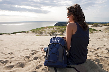 Woman relaxes on sand dune on Curonian Spit, MR, near Klaipeda, Klaipedos, Lithuania