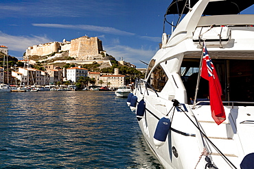 Boat with Union Jack in harbor, citadel, Bonifacio, Corsica, France