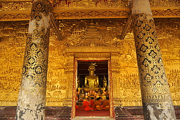 Gallery with golden relief and monks at evening prayer, Wat Mai Suwannaphumaham, Luang Prabang, Laos, Lao Peoples Democratic Republic