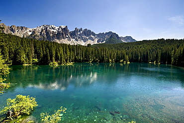 Lake Karersee in the sunlight in front of Dolomites, Nature reserve Schlern Rosengarten, Alto Adige, South Tyrol, Italy, Europe