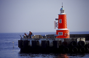 Anglers and lighthouse at harbour of Helsingor, Zealand, Denmark, Europe