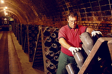 Man turning bottles, Cava Cellar methode champenoise, Codorniu, Sant Sadurni d'Anola, Catalonia, Spain