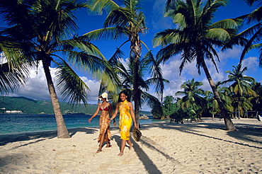 Two women walking along the beach at Cayo Levantado, Bahia de Samana, Dominican Republic, Caribbean