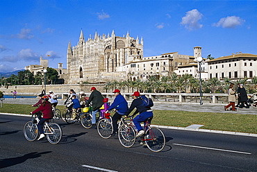 Group of cyclists, Cathedral La Seu, Palma Cathedral, Cathedral of Santa Maria of Palma, Palma de Mallorca, Mallorca, Spain