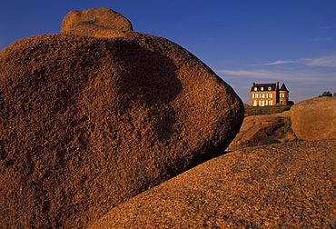 House on limestone boulders in the sunlight, Cote de Granit Rose, Brittany, France, Europe