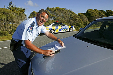 Policeman drawing a speeding ticket, Highway 6, West Coast, South Island, New Zealand, Oceania