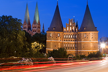 The illuminated Holstentor with St. Mary's church at night, Luebeck, Schleswig Holstein, Germany, Europe