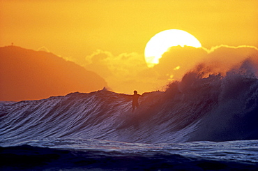 Surfing in the sunset, Hawaii, USA