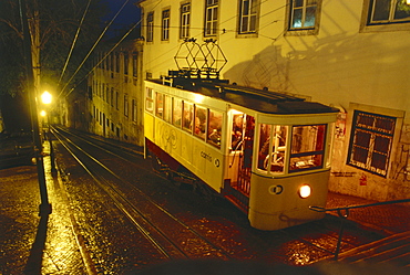 A streetcar going up a steep street at night, Elevador de Santa Justa, Lisbon, Portugal