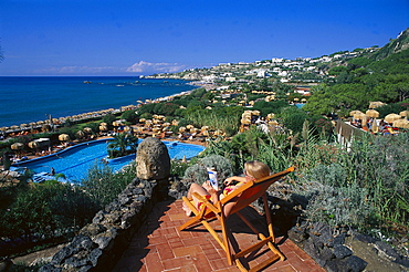 Woman on a deck chair and pool in the sunlight, Therm Garden of Poseidon, Ischia, Campania, Italy, Europe