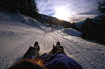 Two persons sledging in the mountains, Staller Sattel, Antholz, South Tyrol, Italy, Europe