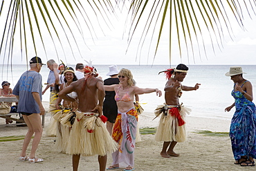 Passengers from the Cruiseship Star Flyer (Star Clippers Cruises) dancing with locals at a beach barbecue party, Fakarava, The Tuamotus, French Polynesia