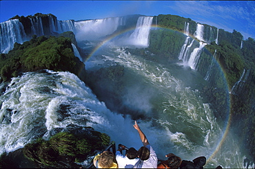 Tourists on a lookout platform watching the IguazË™ waterfalls, Brazil, South America