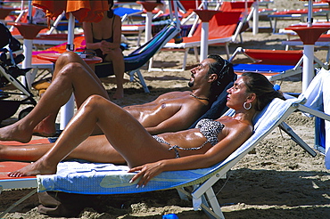 Couple sunbathing on Vieste beach, Vieste, Gargano, Apulia, Italy