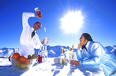 Barkeeper preparing cocktail for woman at ice bar, Lech, Vorarlberg, Austria