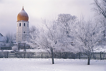 The Bell tower standing behind snow covered trees, Fraueninsel, Lake Chiemsee, Bavaria, Germany