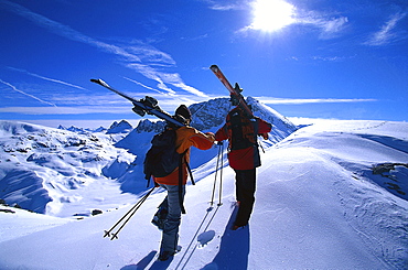 Two people with skis in snow covered scenery, Vorarlberg, Austria, Europe