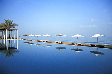 The pool reflecting sunshades, The Chedi Hotel, Muscat, Oman