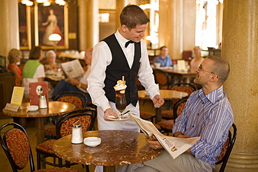 Waiter serving coffee ice, Cafe Central, Waiter serving coffee ice to a guest of Cafe Central, Vienna, Austria