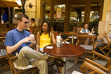 Couple drinking latte macchiato in an open-air cafe, Couple sitting in an open-air Cafe at Liszt Square and drinking latte macchiato, Pest, Budapest, Hungary