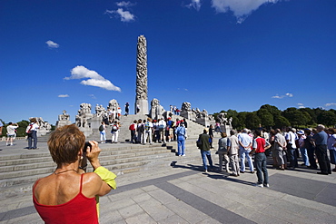 Tourist group on Monolith Plateau, granite sculptures by Gustav Vigeland in Vigeland Park, Oslo, Norway