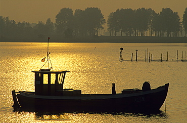 Europe, Germany, Mecklenburg-Western Pomerania, isle of Ruegen, Waase on Ummanz, fishing boat at sunset.