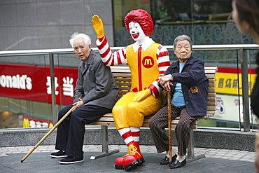 Ronald McDonald figure, pensioners rest on a bench, Fastfood