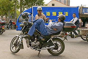 Traffic Shanghai, motorbike taxi, driver, courier, relaxed, lunch break, helmet, street junction