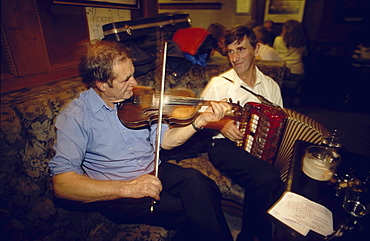 Two men playing traditional music on violin and accordion in Gus O'Connor's Pub, Doolin, County Clare, Ireland00058539