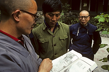 monks study the reprint of a trourist guide from 1932 of Emei Shan, Xixiang Chi monastery and temple, Elephant Bathing Pool, World Heritage Site, UNESCO, China, Asia