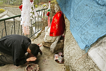 pilgrim prays in front of small statue of monk Shenizi, Nantai temple, Heng Shan south, Hunan province, Hengshan, Mount Heng, China, Asia