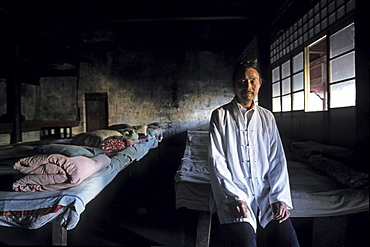 A monk standing at pilgrim's dormitory at Qunxian monastery, Hua Shan, Shaanxi province, China, Asia