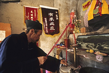 Taoist hermit monk prays at his altar, cliff hermiatge, Hua Shan, Shaanxi province, Taoist mountain, China, Asia